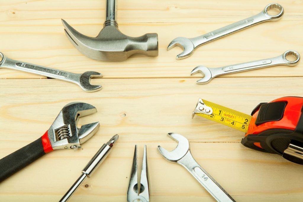 A wooden table displaying various tools, including a ruler and a tape measure, arranged neatly for easy access.