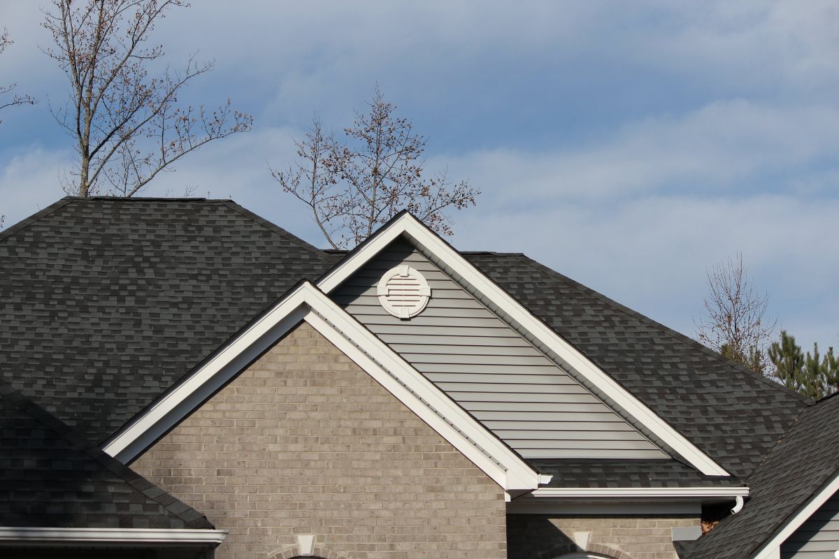 Roof of a house featuring a sloped design and white trim along the edges. 